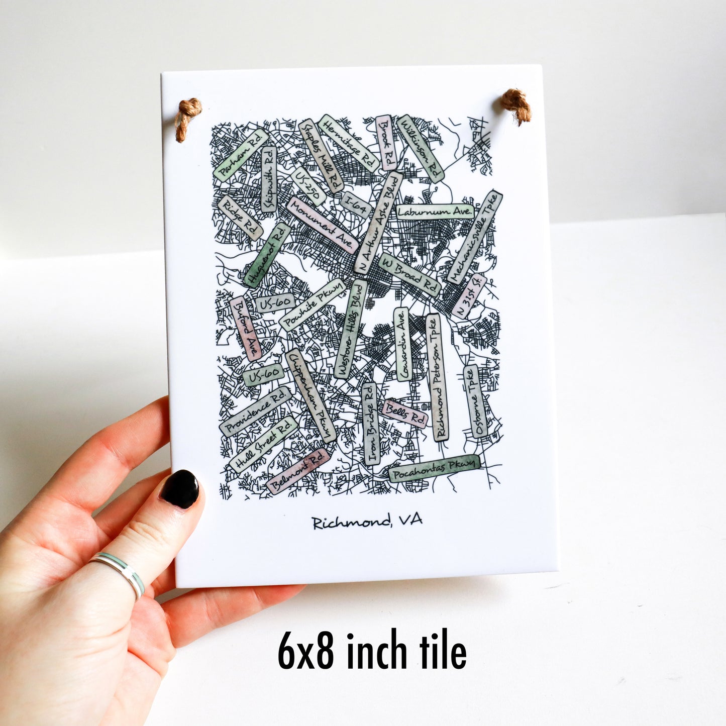 A hand holding a custom city street map on a rectangle tile sign, showing the 6x8 inch tile sign