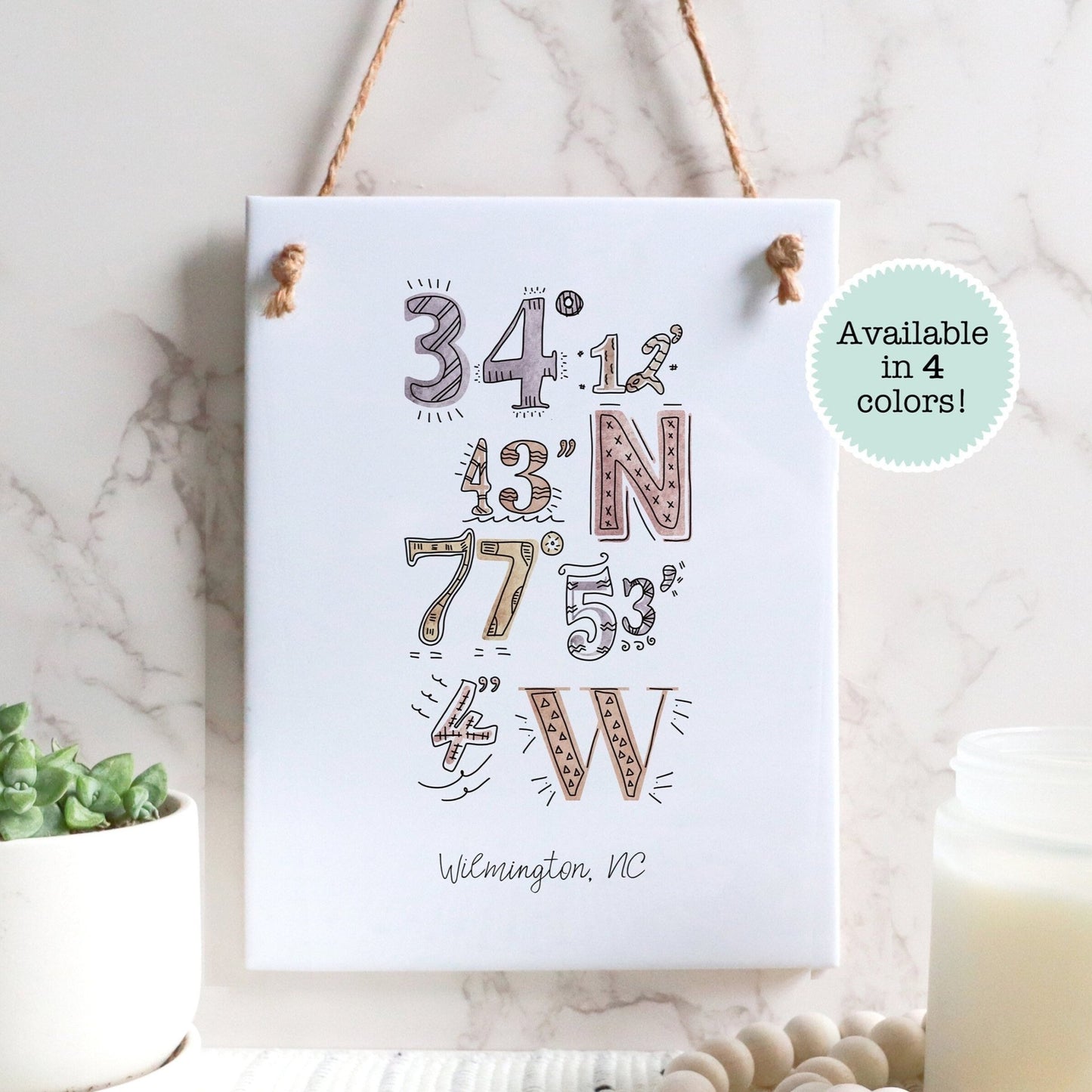 A city drawing of the coordinates of Wilmington NC on a rectangle tile sign, hanging on a wall - Sparks House Co