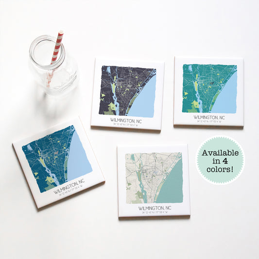 A set of 4 Wilmington NC map coasters sitting on a table with a glass, in four different colors - Sparks House Co