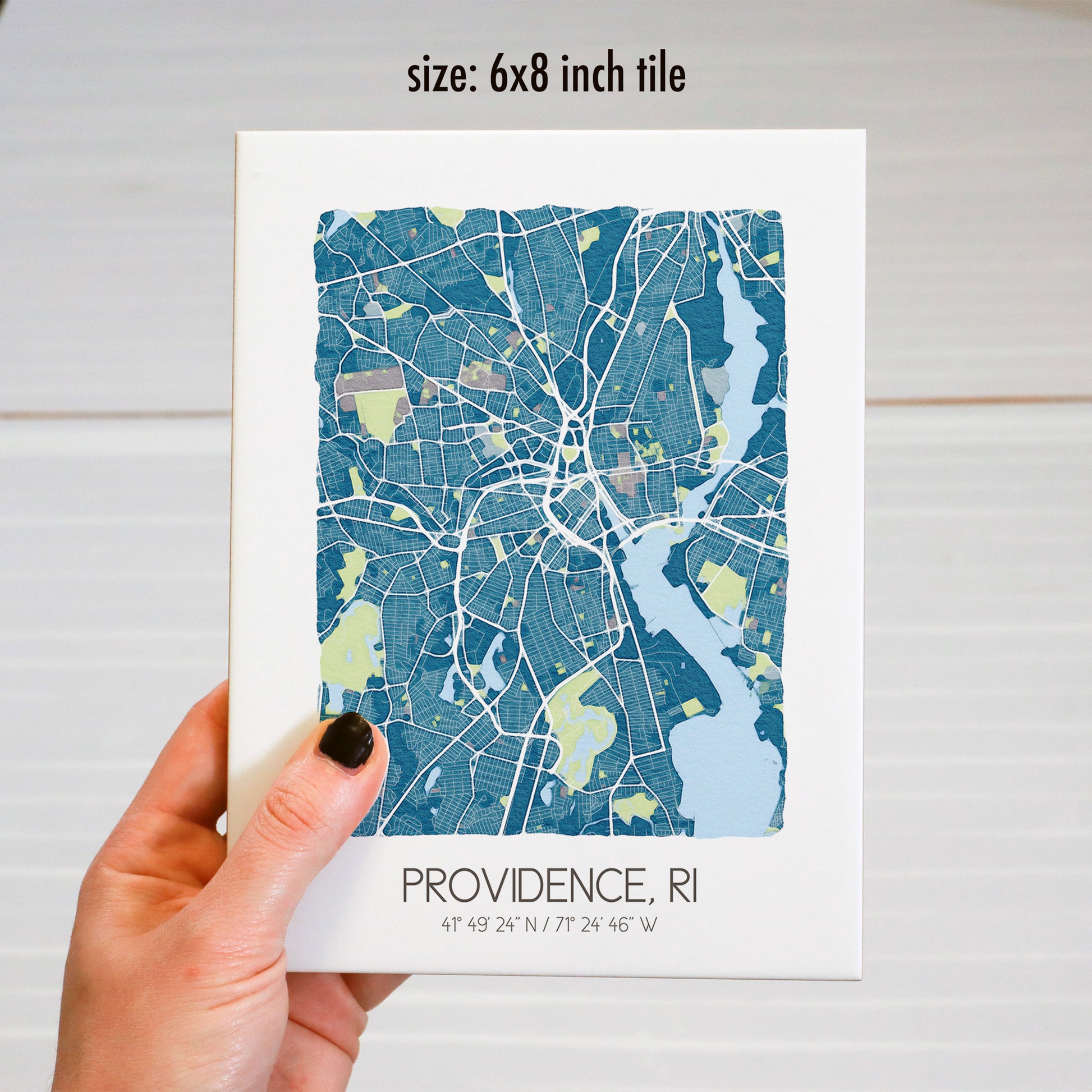 A hand holding a custom city map rectangle tile sign, in the 6x8 inch size