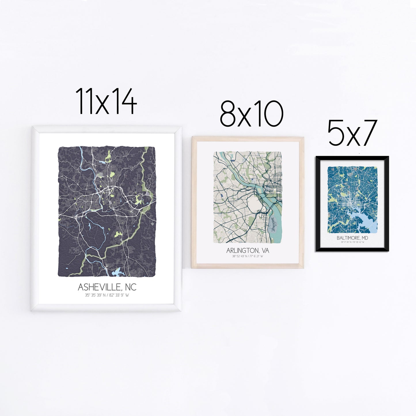Three city map prints displayed on a wall in three different sizes - 11x14, 8x10, 5x7