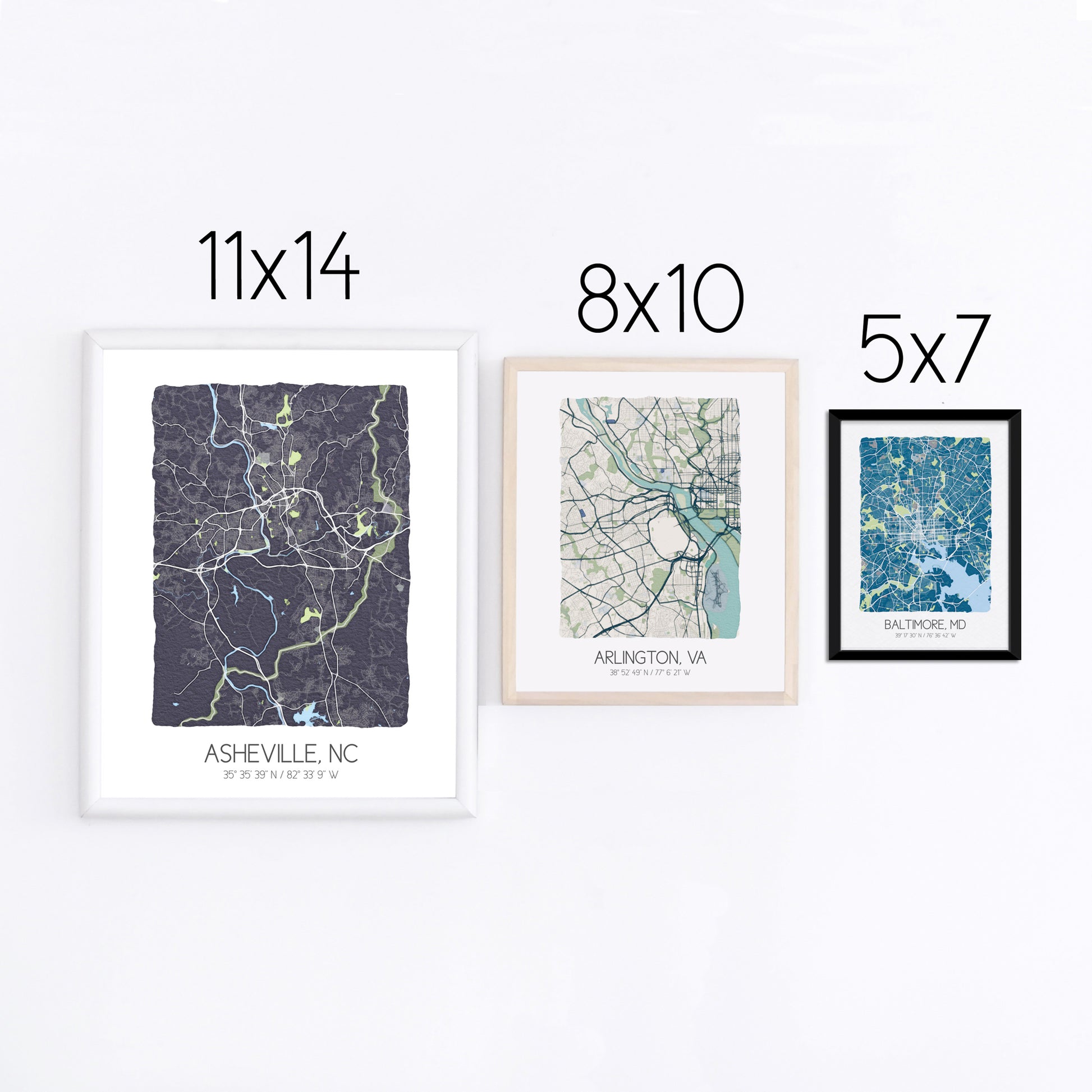 Three city map prints displayed on a wall in three different sizes - 11x14, 8x10, 5x7