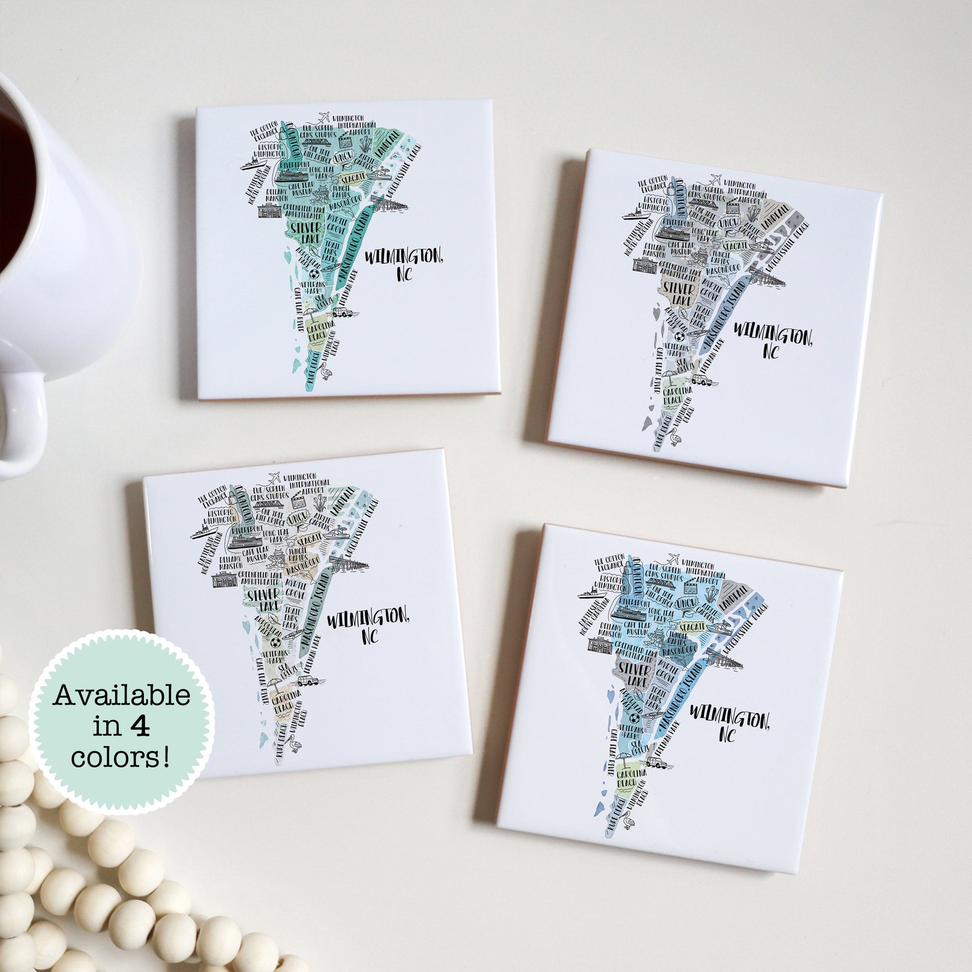 A hand drawn map of Wilmington NC on a set of 4 ceramic coasters, sitting on a table - in 4 colors - Sparks House Co