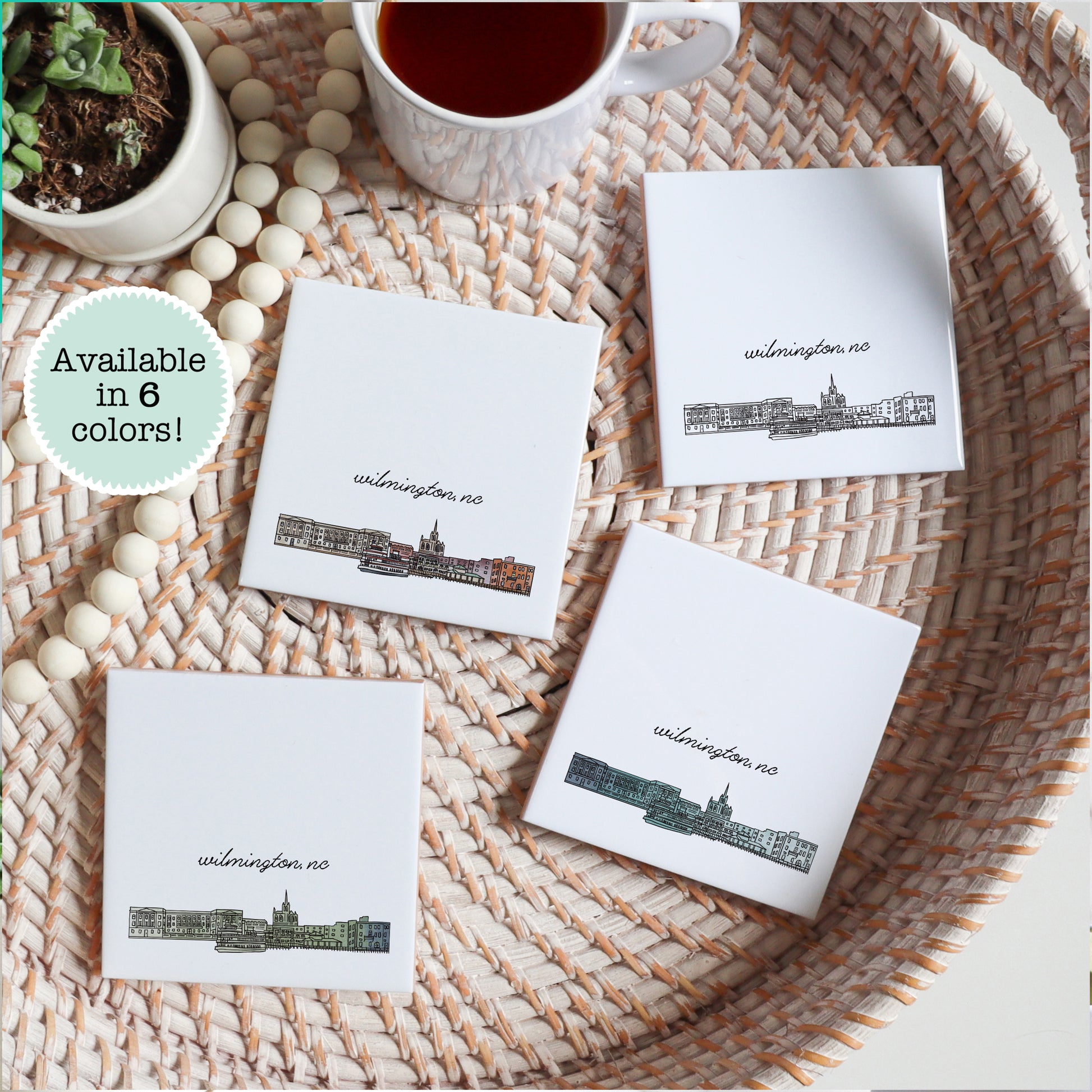 A city drawing of Wilmington NC on a set of ceramic coasters sitting on a tray with a cup of tea - Sparks House Co