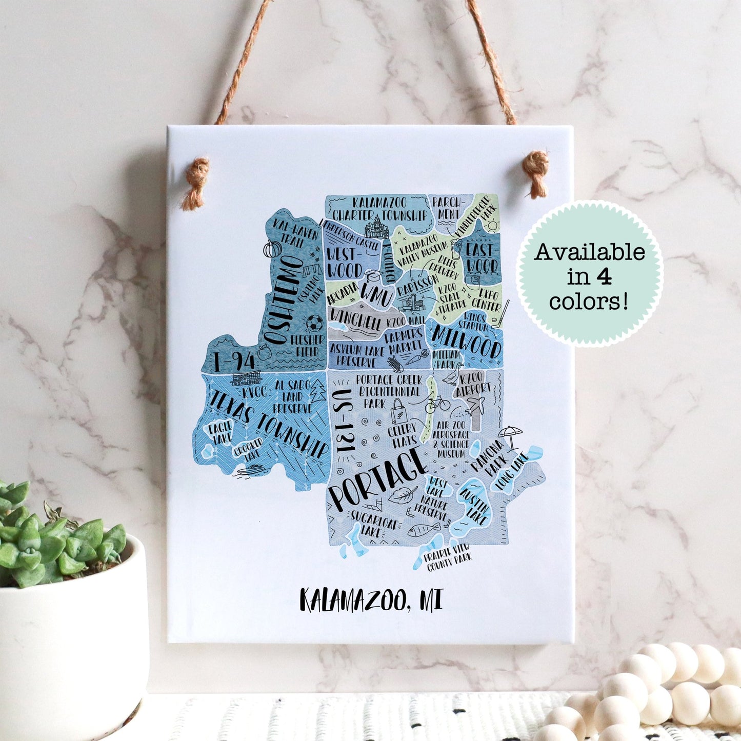 An illustrated map of Kalamazoo MI on a rectangle tile sign, hanging on a wall - in the color blue