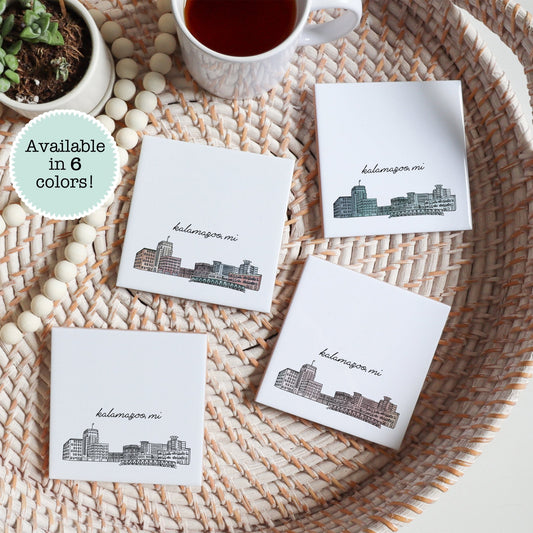 A city drawing of Kalamazoo MI on a set of ceramic coasters sitting on a tray with a cup of tea - Sparks House Co