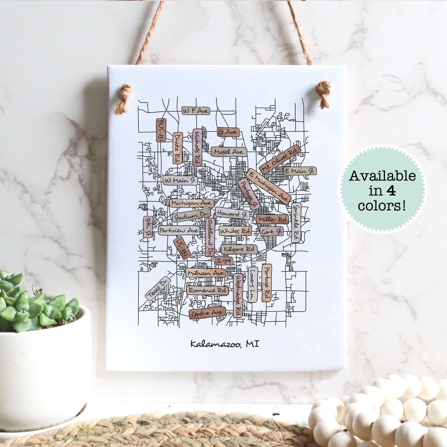 A street map drawing of Kalamazoo MI on a rectangle tile sign hanging on a wall - Sparks House Co