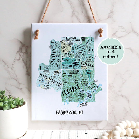 An illustrated map of Kalamazoo MI on a rectangle tile sign, hanging on a wall - Sparks House Co