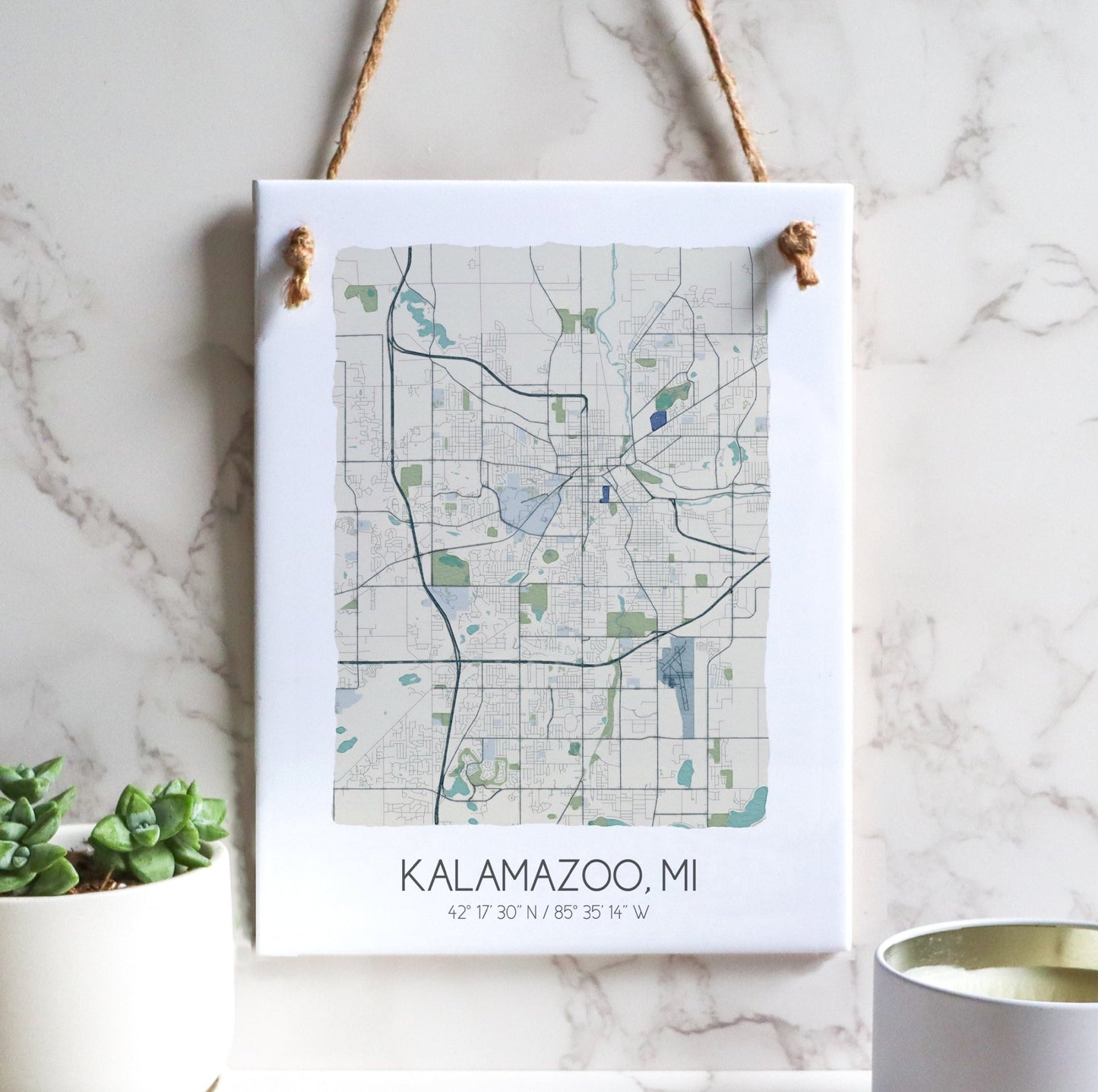 A Kalamazoo MI city map on a ceramic rectangle tile sign hanging on a wall, in beige