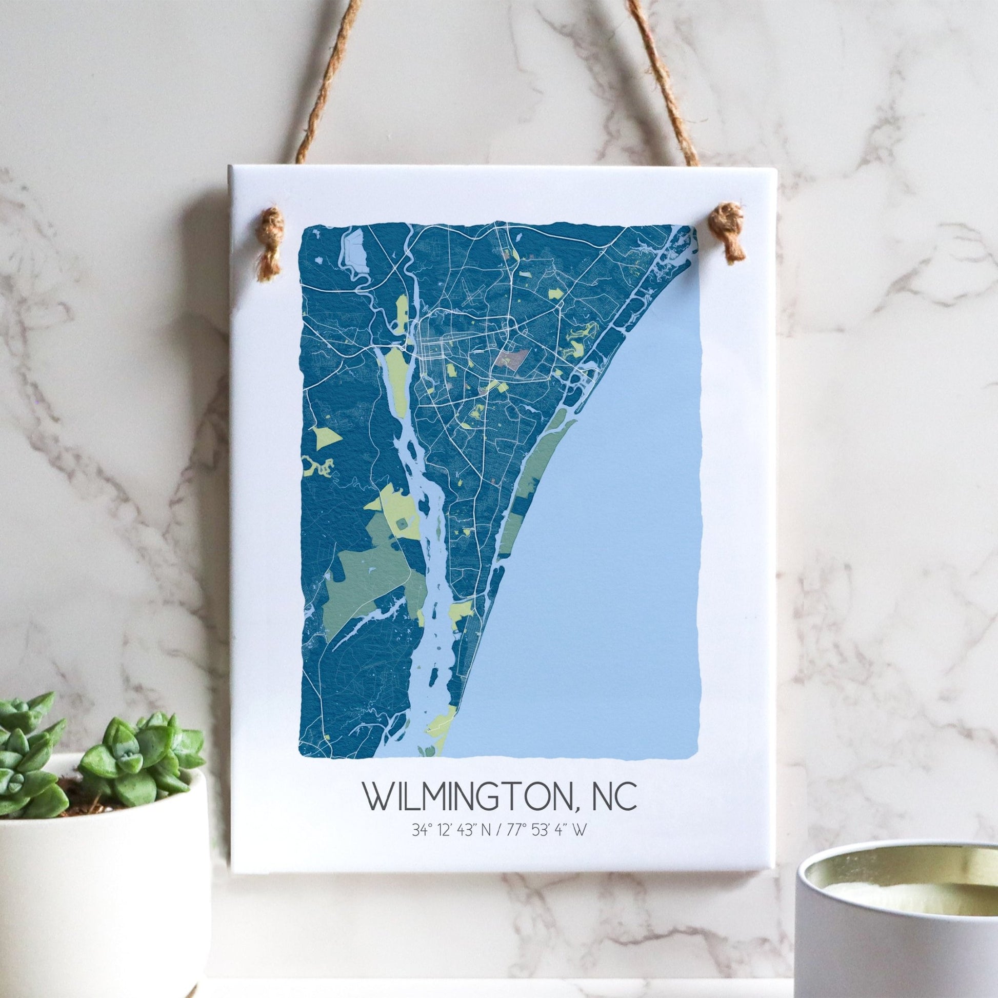 A Wilmington NC city map on a ceramic rectangle tile sign hanging on a wall, in blue