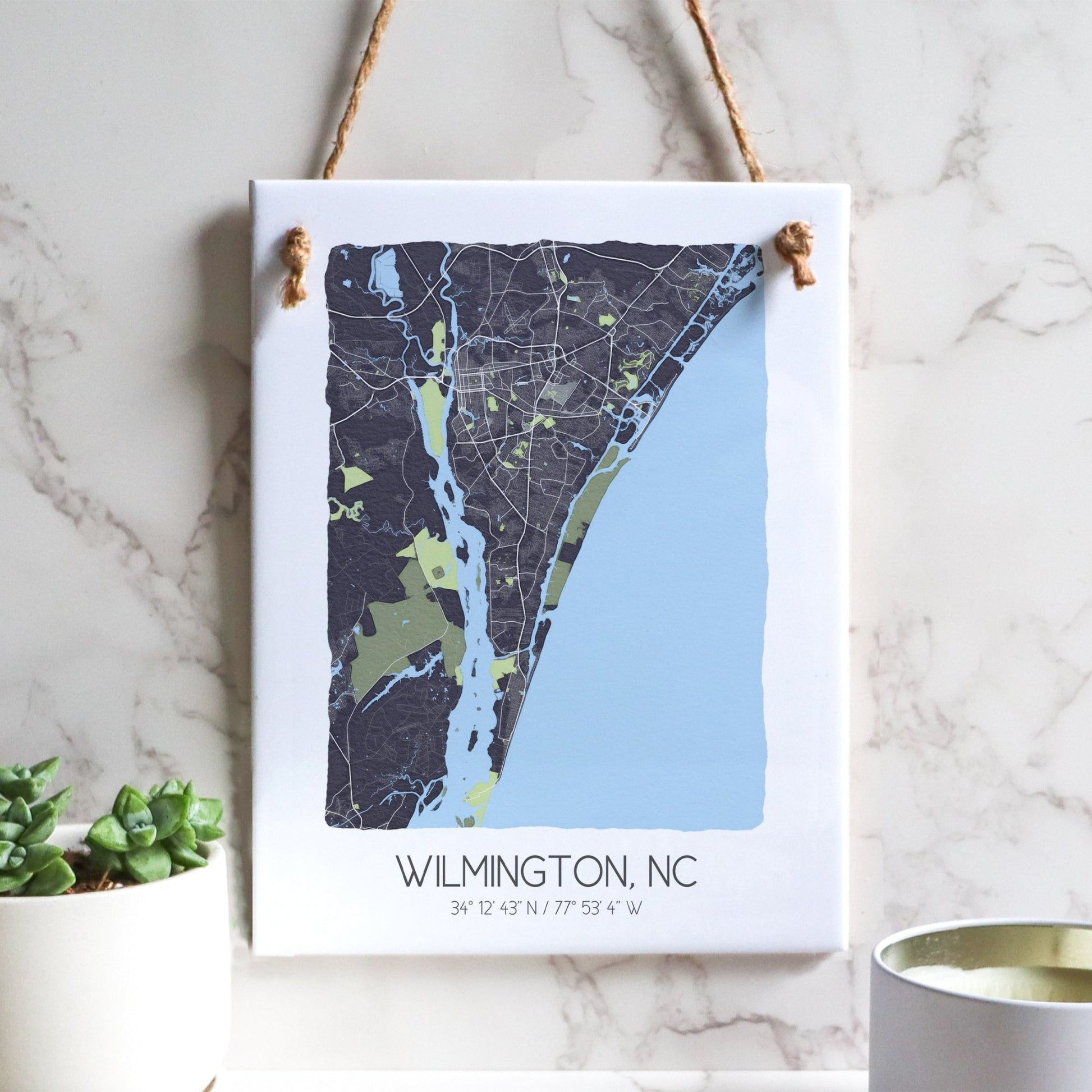 A Wilmington NC city map on a ceramic rectangle tile sign hanging on a wall, in gray