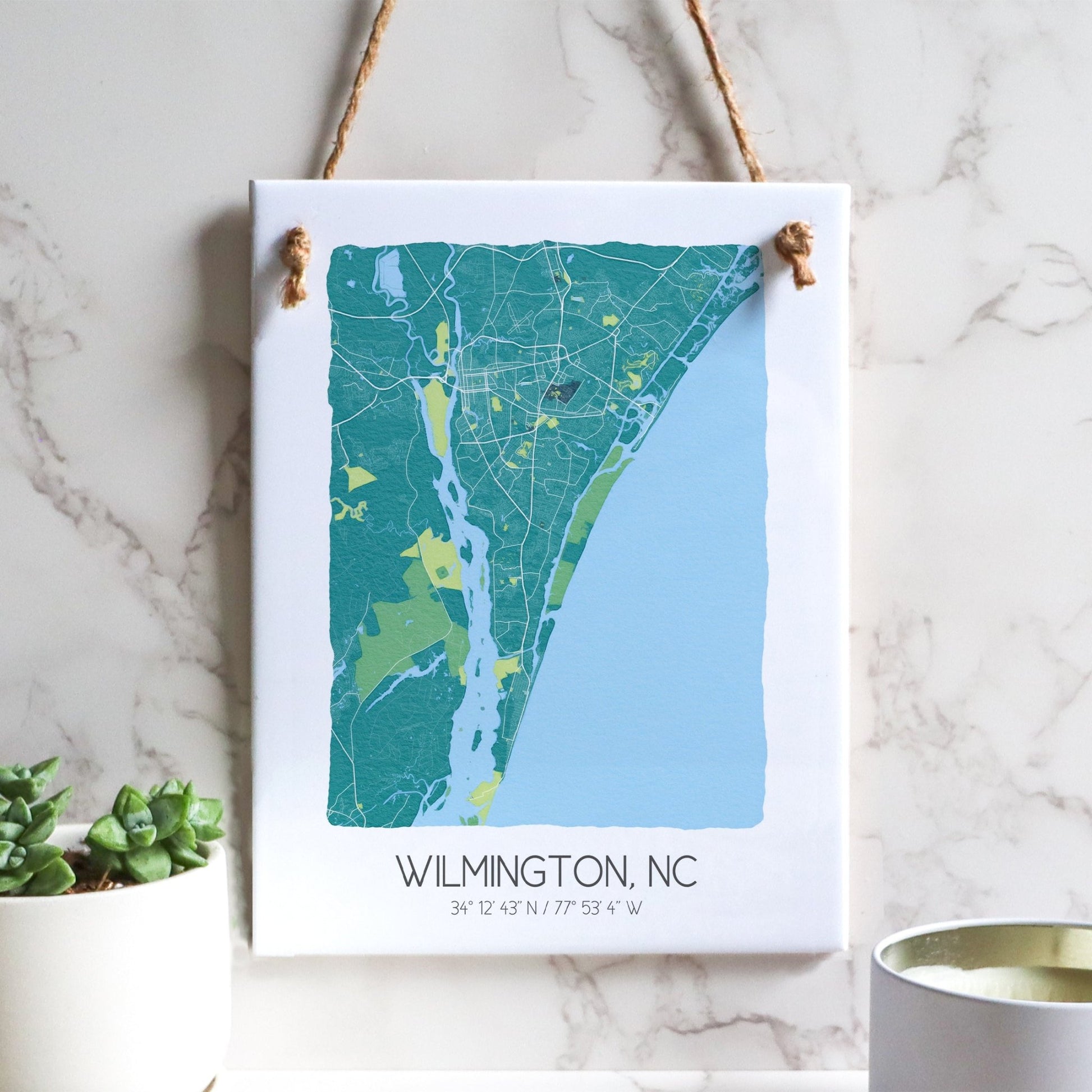 A Wilmington NC city map on a ceramic rectangle tile sign hanging on a wall, in teal